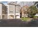 View of building exterior featuring garages, neutral color scheme, and well maintained landscaping at 12855 Madison Pointe Cir # 106, Orlando, FL 32821