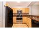 Well-lit kitchen featuring stainless steel appliances, tile backsplash, and light wood cabinetry at 12855 Madison Pointe Cir # 106, Orlando, FL 32821