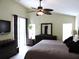 Spacious main bedroom with neutral tones, ceiling fan, and exterior access at 320 Henley Cir, Davenport, FL 33896