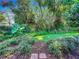 Landscaped backyard with lush greenery and a brick pathway at 648 Brechin Dr, Winter Park, FL 32792