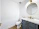 Modern bathroom with gray vanity, white countertop, and round mirror at 648 Brechin Dr, Winter Park, FL 32792