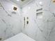 Luxury shower with marble walls, gold fixtures and a rain shower head at 648 Brechin Dr, Winter Park, FL 32792