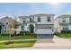 Charming two-story home featuring a clean white facade, manicured lawn, and a paved driveway leading to a spacious garage at 1548 Moon Valley Dr, Davenport, FL 33896