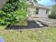 Backyard with a patio, lush greenery, and landscaped garden beds at 5610 King James Ave, Leesburg, FL 34748