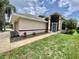 Inviting home featuring well-maintained landscaping, a screened front entry, and a neatly kept lawn at 5610 King James Ave, Leesburg, FL 34748