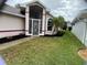 House exterior featuring a screened porch and landscaped yard at 5610 King James Ave, Leesburg, FL 34748