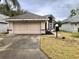 House exterior featuring a two-car garage and well-maintained lawn at 5610 King James Ave, Leesburg, FL 34748