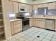 Galley-style kitchen with stainless steel appliances and wood cabinets at 5610 King James Ave, Leesburg, FL 34748