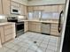 Well-lit kitchen with neutral cabinets and stainless steel appliances featuring tile floors and plenty of natural light at 5610 King James Ave, Leesburg, FL 34748