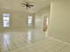 Large living area featuring white tile floors and light neutral walls offering plenty of natural light at 5610 King James Ave, Leesburg, FL 34748