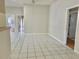 Large living space with white tile floors and light neutral walls with plenty of natural light from the adjacent rooms at 5610 King James Ave, Leesburg, FL 34748