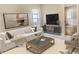 Bright living room featuring a comfortable sofa, modern artwork, and natural light from the window at 5610 King James Ave, Leesburg, FL 34748