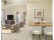 Open-concept living room featuring tile floors, neutral walls, and comfortable seating with dining area and bright, natural light at 5610 King James Ave, Leesburg, FL 34748