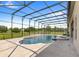 Resort-style pool with covered patio, lush landscaping, and a spacious backyard at 31722 Red Tail Blvd, Sorrento, FL 32776