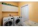 Laundry room with washer, dryer, cabinets and utility sink at 898 Arbormoor Pl, Lake Mary, FL 32746