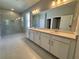 Large bathroom with double vanity, walk-in shower, and neutral colored tiling at 1193 Basalt Ln, Sanford, FL 32771
