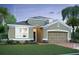 Tan house with a two-car garage and front yard at 1193 Basalt Ln, Sanford, FL 32771