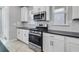 Close-up showcasing stainless steel gas range and modern microwave with white cabinets at 1211 Teal Creek Dr, St Cloud, FL 34771