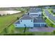 Aerial view showcasing the house with a brick driveway, three-car garage, and view of a lake at 16744 Sanctuary Dr, Winter Garden, FL 34787