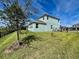 Spacious backyard with black fence, lush greenery, and mature tree at 16744 Sanctuary Dr, Winter Garden, FL 34787