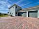 Rear exterior showcasing a spacious three-car garage and a paver driveway at 16744 Sanctuary Dr, Winter Garden, FL 34787