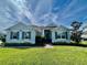 Charming one-story home with beautiful landscaping, blue exterior, shutters and well-manicured lawn at 16744 Sanctuary Dr, Winter Garden, FL 34787