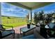 Inviting covered patio with comfortable seating and views of the fenced backyard and green field at 16744 Sanctuary Dr, Winter Garden, FL 34787
