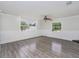 Bright living room features gray wood-look floors, chair rail, modern ceiling fan, and large windows at 1913 South Blvd, Maitland, FL 32751