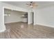 Open-concept living room with wood-look floors, ceiling fan, and view into kitchen at 1913 South Blvd, Maitland, FL 32751