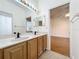 Double vanity bathroom with wood cabinets and view of bedroom at 1125 English Garden Se Ln, Winter Garden, FL 34787