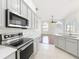 Modern kitchen with gray cabinets, quartz countertops, and stainless steel appliances at 1125 English Garden Se Ln, Winter Garden, FL 34787