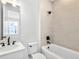 Modern bathroom with tub, shower, light tile, and vanity with dark hardware at 2138 Whitney Marsh Aly, Orlando, FL 32804