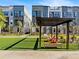 Modern townhome exteriors with lush green space, pergola, and seating area at 2138 Whitney Marsh Aly, Orlando, FL 32804