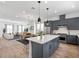 Open concept kitchen with an island, stainless appliances, and modern pendant lighting adjacent to the living room at 2138 Whitney Marsh Aly, Orlando, FL 32804
