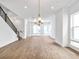 Bright, open living room with hardwood floors, modern light fixture, and staircase at 2138 Whitney Marsh Aly, Orlando, FL 32804