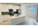Open concept kitchen with island, white cabinets and gray backsplash at 366 Switchgrass Loop, Minneola, FL 34715