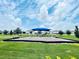 Community playground with swings, a slide, and a shaded canopy, surrounded by grassy areas and park benches at 366 Switchgrass Loop, Minneola, FL 34715