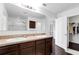 Bathroom with double sinks, a large mirror, a walk-in shower, a closet, and dark hardwood floors at 205 Hamlet Rd, Davenport, FL 33837