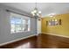 Dining room with hardwood floors, a decorative chandelier, and large windows providing natural light at 205 Hamlet Rd, Davenport, FL 33837