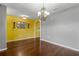 Dining room featuring hardwood floors, an ornate chandelier, and a stylish decorative mirror on a warm yellow accent wall at 205 Hamlet Rd, Davenport, FL 33837