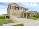 Inviting two-story home featuring red shutters, a two-car garage, screened in porch, and well-maintained landscaping at 205 Hamlet Rd, Davenport, FL 33837