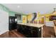 Kitchen with island seating, modern appliances, hardwood floors, and easy access to the dining and living areas at 205 Hamlet Rd, Davenport, FL 33837