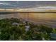 Aerial view of waterfront home with lake access at sunset at 12428 Summerport Ln, Windermere, FL 34786
