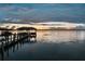 Picturesque boat dock with covered seating area on calm waters during sunset at 12428 Summerport Ln, Windermere, FL 34786