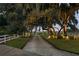 Long gravel driveway lined with trees and white fencing leading to a charming property at 12428 Summerport Ln, Windermere, FL 34786