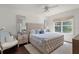 Comfortable main bedroom featuring a tufted headboard, ceiling fan and lots of natural light at 12428 Summerport Ln, Windermere, FL 34786