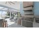 Outdoor kitchen, complete with modern appliances, overlooking a gorgeous pool and waterfront view at 12428 Summerport Ln, Windermere, FL 34786