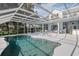 Covered pool area with ample seating, perfect for relaxation and entertaining, overlooking lush grounds at 12428 Summerport Ln, Windermere, FL 34786