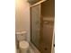 Simple bathroom featuring a tiled shower with a glass door and a standard toilet at 4559 Oak Arbor Cir, Orlando, FL 32808