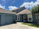 Charming single-story home boasts a well-maintained lawn, attached garage and clay tile roof at 4559 Oak Arbor Cir, Orlando, FL 32808
